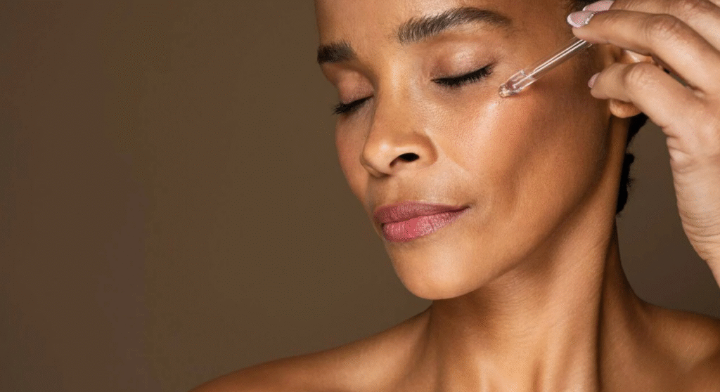 Mulher de pele negra aplicando ácido na face para cuidado de skincare.