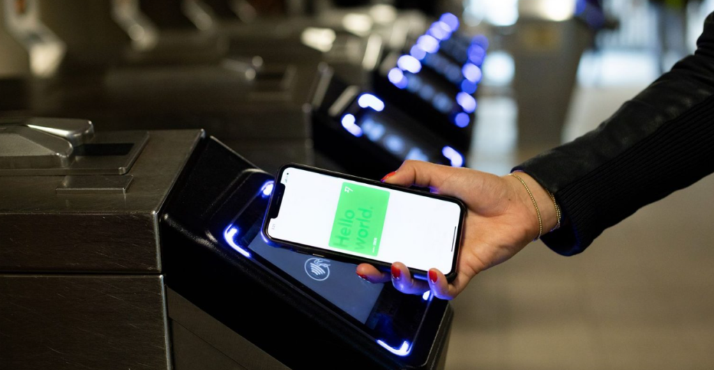 Pessoa sentada segurando um celular com a tela da Wise aberta, mostrando opções para abrir uma conta e enviar dinheiro em segundos.